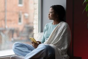 person sitting alone looking out window contemplative